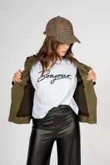 Chaqueta corta color verde militar, con cierre lateral, cuello solapa y detalles de charreteras en los hombros.