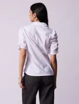 Camisa blanca de algodón, marca Zac & Rachel. Cuello a la base con solapa y escote en V. Abertura central con botones. Mangas 3/4 con frunce. Laterales en tejido modal.