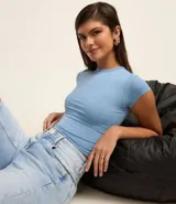 Blusa blanca de poliamida con cuello redondo y mangas cortas.