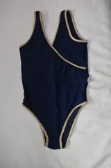 Traje de baño enterizo azul marino metalizado con breteles y contorno en color beige.