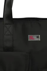 Cartera tipo tote de poliéster color negro, con doble asa corta de mano y correa larga extraíble ajustable para colgar del hombro. Tiene cierre superior y dos bolsillos delanteros, uno con solapa y otro con cierre.