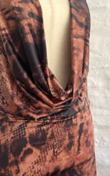 Vestido corto ajustado al cuerpo, con estampado animal print en tonos marrones y negros. Tiene escote en V pronunciado y breteles finos.