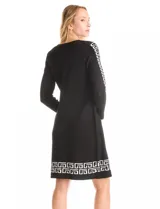 Vestido negro de manga larga con cuello redondo y diseño de cárdigan abierto superpuesto. Presenta un patrón geométrico blanco en las mangas y en el dobladillo.