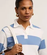 Remera de manga larga con cuello polo, a rayas horizontales anchas de color rosado y blanco.