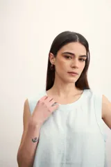 Blusa color crema sin mangas, de lino, con cuello redondo y corte recto.