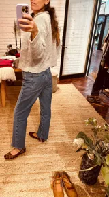 Sweater tejido en boucle color gris, de corte holgado y cuello con capucha.