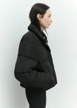 Campera puffer negra con cuello de piel sintética removible, cierre frontal con cremallera y botones a presión, bolsillos laterales con ribete, mangas largas con puños elásticos, diseño crop, acolchado, oversize y forro interior.