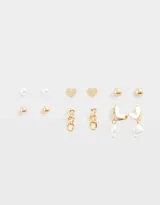 Set de seis pares de aros dorados con diferentes diseños: perlas, corazones texturados y esferas.