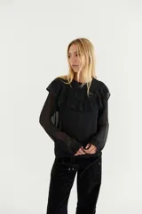 Blusa de gasa azul marino traslúcida con volados en los hombros y mangas largas abullonadas.