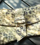 Bolso de mano con estampado animal print y correa corta.