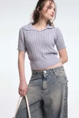 Top tejido de punto color lila con cuello polo y mangas cortas.