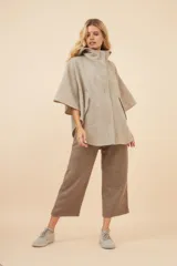 Capa amplia color marrón con capucha, cierre metálico y bolsillos delanteros. Espalda con canesú y botones laterales para generar la manga.