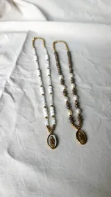 Collar de cuentas grises y perlas blancas con dije de la virgen milagrosa plateado.