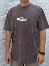 Remera oversize de manga corta, color marrón oscuro con efecto gastado (acid wash), con un logo ovalado blanco que contiene el texto "OSTEN" en el centro del pecho.