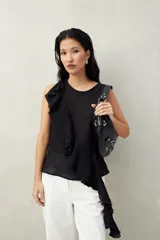 Top blanco de tencel sin mangas, de corte asimétrico, con volados en diagonal.