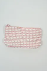Neceser pequeño de tela con textura de toalla, color rosa y blanco, con cierre superior.