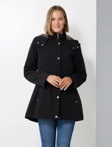 Gabardina impermeable de mujer, color marrón topo, con capucha desmontable y forro interno de abrigo desmontable. Presenta abertura central con cierre oculto y botones a presión, y bolsillos delanteros.