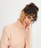 Blusa de punto color blanco, con cuello alto, manga larga y diseño liso.