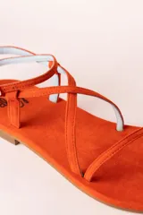 Sandalias planas color naranja de tiras finas, con suela plana y puntera descubierta.