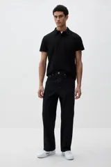 Chomba negra de piqué de algodón, corte slim fit, con cuello clásico, tapeta de dos botones y mangas cortas.
