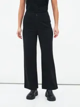 Pantalón negro de corte palazzo con bolsillos delanteros y botón.