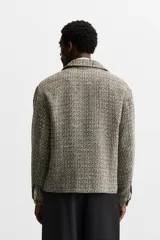 Sobrecamisa de tweed multicolor con cuello solapa, cierre frontal con cremallera, bolsillos laterales y puños abotonados.