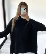 Sweater negro de tejido de punto acanalado, con cuello alto caído y corte mega oversize.