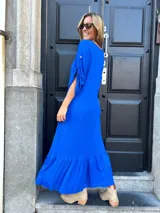 Vestido largo azul eléctrico con escote en V, mangas cortas con detalle de lazo y falda con volantes.