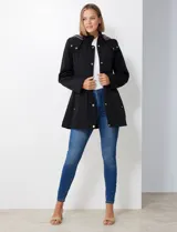 Gabardina impermeable de mujer, color marrón topo, con capucha desmontable y forro interno de abrigo desmontable. Presenta abertura central con cierre oculto y botones a presión, y bolsillos delanteros.