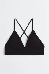 Top de bikini negro con copas de triángulo con relleno extraíble, breteles finos ajustables y tiras cruzadas en la espalda.