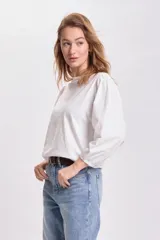 Remera blanca de mangas 3/4 abullonadas.