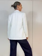 Blazer blanco de poliéster, con corte recto, botones a tono, manga larga y cierre frontal.