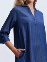 Vestido corto azul de tencel con cuello solapa y escote en V. Manga 3/4 regulable con presilla y botón.