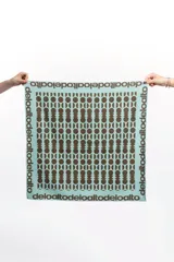 Pañuelo cuadrado de color celeste con estampado de círculos y semicírculos marrones.