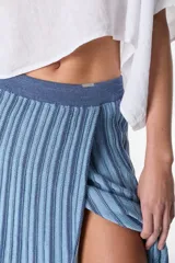 Falda midi tejida a rayas verticales en tonos celeste y azul, con cintura elástica y abertura lateral.