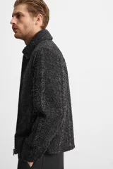 Sobrecamisa regular fit confeccionada en tejido con algodón, color gris oscuro con finas rayas verticales en blanco. Cuello solapa, manga larga con puño abotonado, bolsillos laterales y cierre frontal con cremallera.