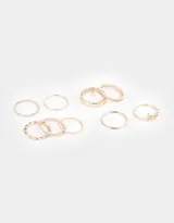 Set de nueve anillos dorados con diferentes diseños: lisos, texturizados, con forma de corazón y con la palabra 'love'.