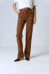 Pantalón jean color marrón, de tiro alto, corte recto y levemente acampanado. Presenta bolsillos delanteros y costuras visibles.
