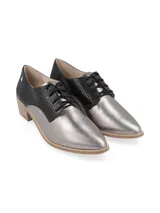Zapato acordonado de cuero color plateado con puntera fina y detalle de cuero marrón en el talón.