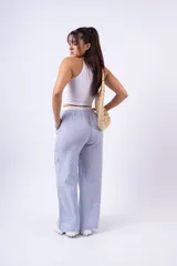 Pantalón de tela a rayas verticales celestes y blancas, con corte amplio, cintura elástica y cordón ajustable.