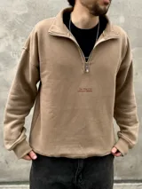 Buzo color beige de felpa con frisa gruesa, corte boxy y medio cierre. Estampado minimalista con la frase "The Wise Club Exclusive Members".
