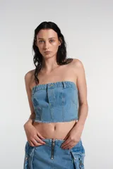 Corset de denim azul ajustado con cierre lateral y bolsillos decorativos.