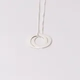Gargantilla de plata con cadena de eslabones cuadrados y dije de dos aros entrelazados.