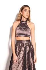 Top marrón de tafeta con diseño acolchado de rombos, escote halter con volados y espalda descubierta con cierre de botones.