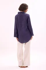 Camisa de manga larga, color rosa viejo, con cuello camisero y botones frontales. Presenta un calce holgado.