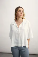 Blusa negra de lino con cuello polo y mangas cortas amplias.