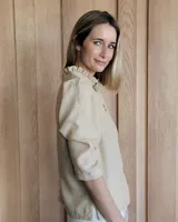 Camisa color beige claro con cuello con volados y mangas 3/4 abullonadas.