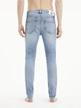 Jeans skinny de tiro bajo, color azul claro vintage con efecto desgastado y rotos en las piernas.