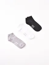 Pack de tres pares de soquetes tobilleros de algodón en color negro, blanco y gris, con logo de la marca en el tobillo.