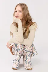 Top de tejido en lurex dorado, con escote a la base y manga larga, diseñado para ajustarse al cuerpo.